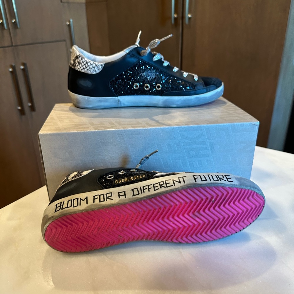 Golden Goose sneakers with hot pink bottoms.